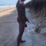 Muscular black shows off his huge cock on the beach