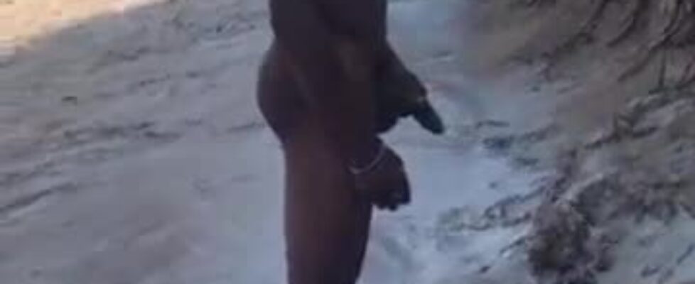 Muscular black shows off his huge cock on the beach