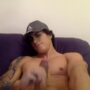 Muscular tattooed dude strokes his cock in the sofa