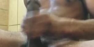 Ecstatic black guy masturbates his huge cock in bathroom